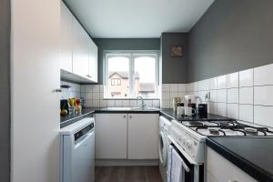 een keuken met witte apparatuur en een raam bij Cosy 2 BDR Flat with Free Parking close to Tower Bridge in Londen