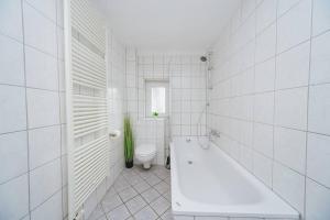 baño blanco con bañera y aseo en City Wohnung Zentral 89-11 en Dortmund