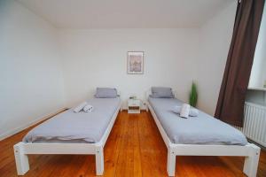 2 camas en una habitación con suelo de madera en City Wohnung Zentral 89-11 en Dortmund