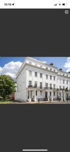 a large white building with a fence in front of it at Leamington Loft in Leamington Spa