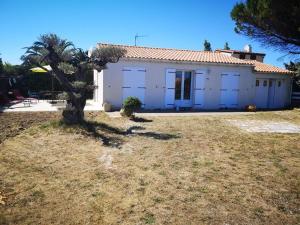 a white house with a tree in front of it at Maison calme avec jardin, proche plages et centre, 2 chambres, 4 couchages, ménage inclus - FR-1-246A-163 in Saint-Denis-dʼOléron