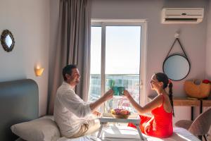 un hombre y una mujer sentados en una mesa en una habitación en Hotel Parthenon Rodos city, en Rodas