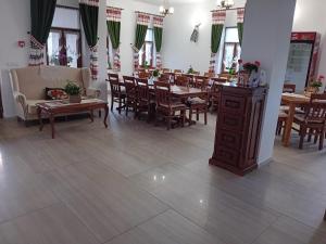 a dining room with wooden tables and chairs and a room with tables and chairs at Maramures BELVEDERE in Petrova