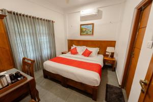 a hotel room with a bed with a red blanket at SeaCoast Inn FortKochi in Fort Kochi