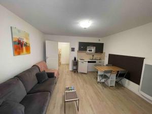 a living room with a couch and a table at Valberg Centre - Résidence Val d'Azur - Studio 29m2 in Péone +6 photos