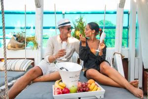 a man and woman sitting on a swing with a bowl of fruit at Hotel Parthenon Rodos city in Rhodes Town