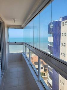 a balcony of a building with a view of the ocean at Apto. a 40m da praia - Itanhaém. in Itanhaém