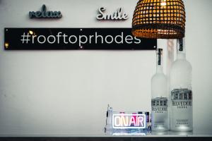 a table with a lamp and a bottle of alcohol at Hotel Parthenon Rodos city in Rhodes Town