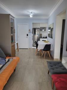 a living room with a table and a kitchen at Apto. a 40m da praia - Itanhaém. in Itanhaém