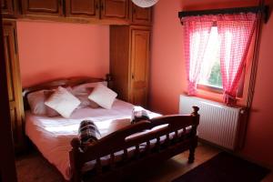 a bedroom with a bed with red walls and a window at Kuća za odmor Šegota in Brinje