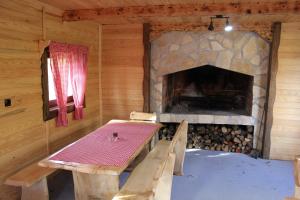 una mesa de comedor en una cabaña de madera con chimenea en Kuća za odmor Šegota, en Brinje