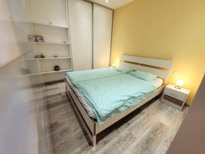 een slaapkamer met een bed met een blauw dekbed bij Comfy & stylish flat in the city centre + parking in Bratislava
