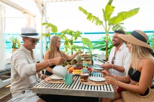 a group of people sitting around a table eating food at Hotel Parthenon Rodos city in Rhodes Town