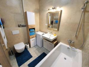 a bathroom with a tub and a sink and a toilet at Comfy & stylish flat in the city centre + parking in Bratislava