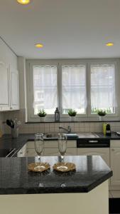 a kitchen with two wine glasses on a counter at Wohnung „Perla Paradiso“ in Fluelen
