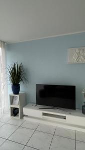 ein Wohnzimmer mit einem Flachbild-TV an der Wand in der Unterkunft Wohnung „Perla Paradiso“ in Fluelen