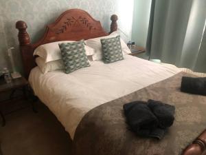 een slaapkamer met een groot bed met witte lakens en kussens bij 2 Bedroom entire Bungalow with off road parking in the heart of Stoke in Stoke on Trent