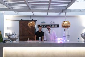 two men standing behind a counter in a kitchen at Hotel Parthenon Rodos city in Rhodes Town