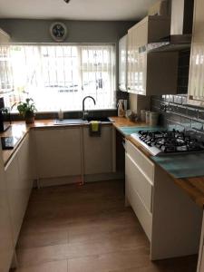 een keuken met een wastafel en een fornuis top oven bij 2 Bedroom entire Bungalow with off road parking in the heart of Stoke in Stoke on Trent