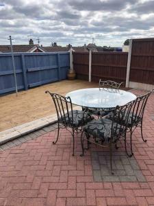 een tafel en stoelen op een patio bij 2 Bedroom entire Bungalow with off road parking in the heart of Stoke in Stoke on Trent