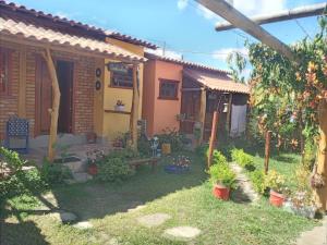 Casa dos Sonhos Hospedaria في Sêrro: حديقة امام بيت به نباتات