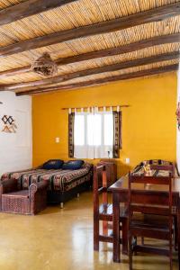 a bedroom with a bed and a table and a couch at Posada Suri Huasi in Tilcara