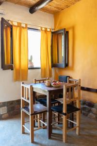 comedor con mesa de madera y sillas en Posada Suri Huasi en Tilcara