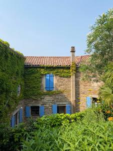 an old stone house with ivy on it at Lou-Pelou in Gravières