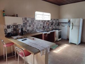 a kitchen with a counter and a refrigerator at Casa LB com estacionamento privado in Boa Vista