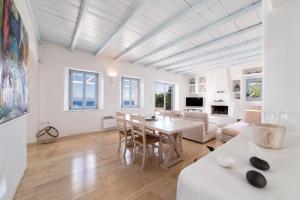 a white living room with a table and chairs at Azure Villa Paros in Drios