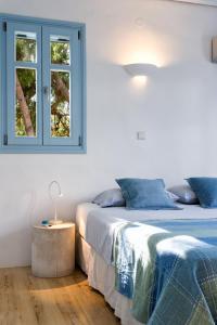 two beds in a white room with a window at Azure Villa Paros in Drios