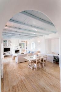 a white living room with a table and chairs at Azure Villa Paros in Drios