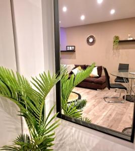 - un salon avec un canapé et une plante de palmier dans l'établissement st Laurent cocon, à Pont-à-Mousson