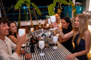a group of people sitting at a table with wine glasses at Hotel Parthenon Rodos city in Rhodes Town