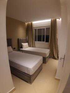 Habitación de hotel con 2 camas y ventana en Appart happiness family only en Tánger