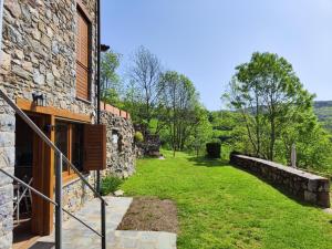 - une vue extérieure sur une maison en pierre avec une cour dans l'établissement La Cabanya de Can Menut, à Molló