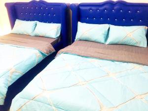 Duas camas sentadas uma ao lado da outra num quarto em MGH Space Rental 