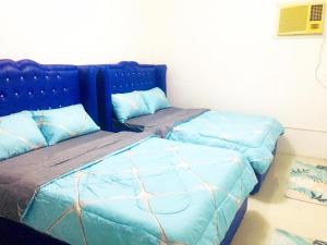 Duas camas com capas azuis num quarto em MGH Space Rental 