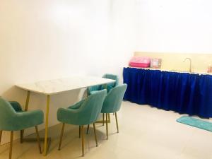 uma mesa e cadeiras num quarto com cortinas azuis em MGH Space Rental 
