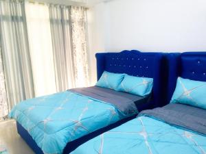 um quarto com 2 camas com edredões azuis em MGH Space Rental 