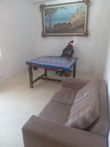 ein Wohnzimmer mit einem Sofa und einem Tisch in der Unterkunft Hostel Leonardo in Vitória