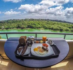 bandeja de desayuno en una mesa en el balcón en Diyawanna Leisure en Rajagiriya