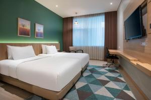 a hotel room with a large bed and a desk at Grand Tjokro Premiere Bandung in Bandung