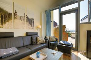 ein Wohnzimmer mit einem Sofa und einem Tisch in der Unterkunft Ostsee - Reetdachhaus Nr 43 "Ostseestern" im Strand Resort in Heiligenhafen