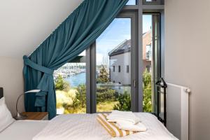 a bedroom with a window with a view of the water at Ostsee - Reetdachhaus Nr 43 "Ostseestern" im Strand Resort in Heiligenhafen