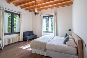 a bedroom with a large bed and a blue chair at Casa Maristany in Camprodon