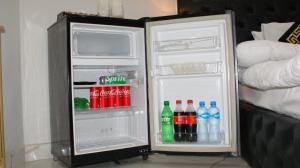 an open refrigerator filled with drinks and soda at Hotel Orange One in Lahore