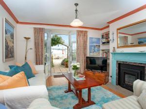 uma sala de estar com uma lareira e uma mesa em Port View Cottage em Shaldon