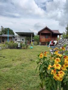 um quintal com uma casa e algumas flores amarelas em PJ Kingdom Camps 