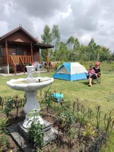 um par de pessoas sentadas num quintal com uma tenda em PJ Kingdom Camps 